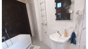 A bathroom with a bathtub, a sink, and a mirror.