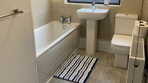 A bathroom with a bathtub, a sink, and a toilet. - Consett Shotley Bridge - Stylish Spacious Three Bedroom Apartment (Consett)