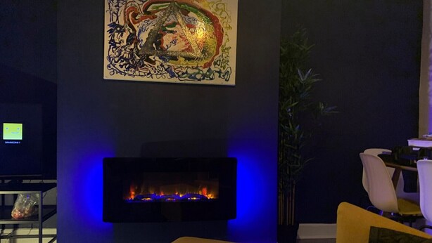 A living room with a fireplace, a painting on the wall, and a plant. - Consett Shotley Bridge - Stylish Spacious Three Bedroom Apartment (Consett)