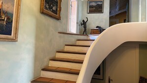 A staircase with a handrail, leading to a landing with a statue and framed artwork. - Mas provençal with tennis court, swimming pool and games and sports room (Velaux)