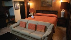 Ein Hotelzimmer mit Bett, Sofa, Couchtisch und Lampe.