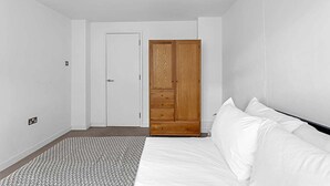 Un dormitorio con cama, armario y puerta.