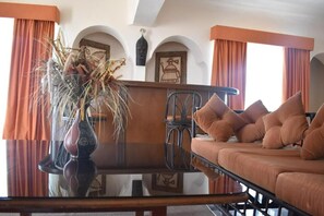 Relax in this inviting living area with a comfortable sofa, matching ottoman, and decorative vase.