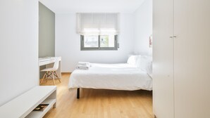 A minimalist bedroom with a bed, a desk, and a chair. - Inside Barcelona Apartments Princep (Barcelona)
