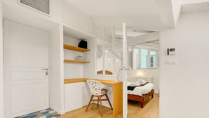 Ein gemütliches Schlafzimmer mit Bett, Nachttisch und Schreibtisch mit Stuhl.