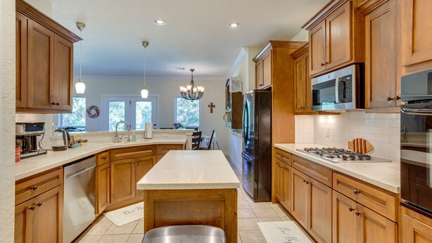 A spacious kitchen with wooden cabinets, stainless steel appliances, and a large island. - Quaint Noble Home: 6 Mi to University of Oklahoma! (Noble)