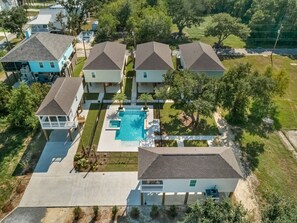 Relax by the pool in a serene, two-story home surrounded by a lush lawn and mature trees.