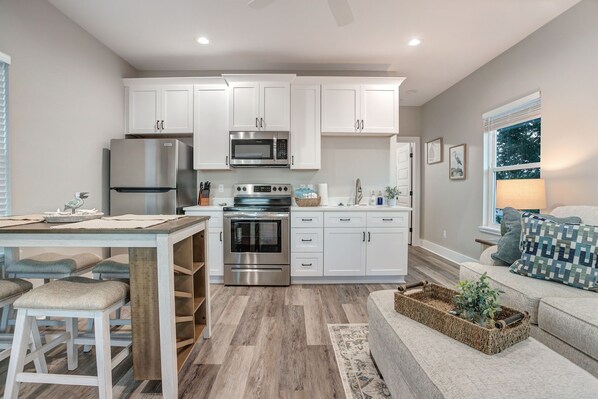 Enjoy cooking in this well-equipped kitchen with stainless steel appliances, a dining table, and comfortable seating area.