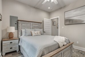 Relax in a serene bedroom with a large bed, nightstand, and abstract art.