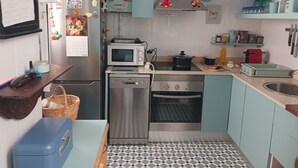 A compact kitchen with a refrigerator, microwave, stove, and sink. - Habitación Privada con Cuarto de Baño (Cádiz)