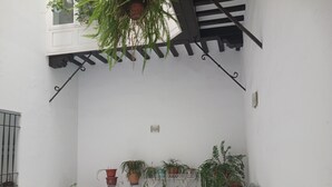 A small, enclosed patio area with potted plants and a bicycle. - Habitación Privada con Cuarto de Baño (Cádiz)