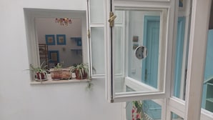 A room with a window, a mirror, and potted plants. - Habitación Privada con Cuarto de Baño (Cádiz)