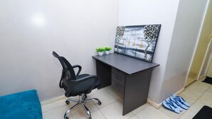A small office space with a desk, chair, and a painting on the wall. - Songeza Furnished Accomoda-super Studio,embakasi (Nairobi)