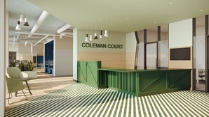 A reception area with a green counter, a sign reading "COLEMAN COURT," and a striped floor. - Coleman Court Summer Accommodation (Cork)