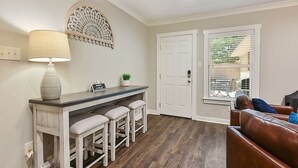 Een keuken met een bar, witte muren en een houten vloer.