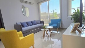 A modern office space with a sofa, yellow chair, and a desk with a computer. - Lindo y moderno apartment in lovely Samborondon with WiFi, AC (Guayaquil)
