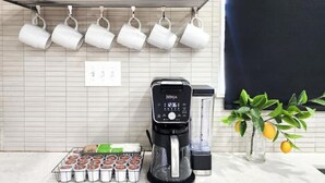 A kitchen with a coffee maker, muffin tray, and a potted plant. - Modern Industrial House + Guesthouse in Midtown (Phoenix)