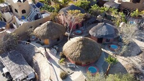 A model of a village with thatched-roof houses, a swimming pool, and a staircase leading to a higher level.