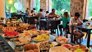 A buffet with various food items and a group of people dining. - Cabañas del Cerro (El Nihuil)