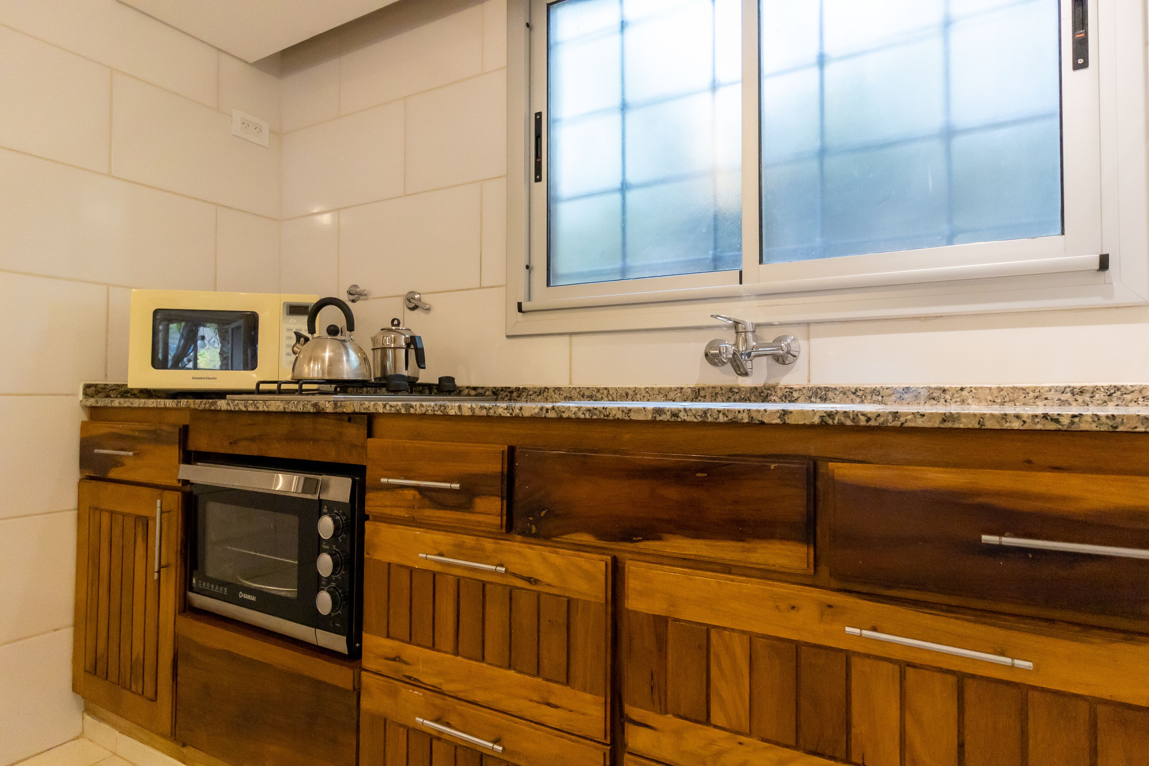 A kitchen with wooden cabinets, a microwave, and a built-in oven.