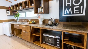 A modern kitchen with wooden cabinets, a built-in oven, and a 'HOME' sign on the wall. - Cabañas del Cerro (El Nihuil)