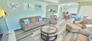 A living room with a sofa, armchairs, a coffee table, and artwork on the walls. - Casa Rosita (South Padre Island)