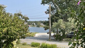 A residential street with a view of a lake, houses, and greenery. - Relaxing Water view Onset Beach 3 bedrooms walking distance to everything (Wareham)