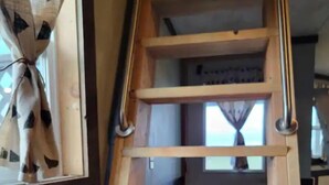 Una escalera interior de madera con varios peldaños y barandillas.