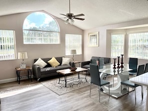 Relax in this stylish living room with a large window, ceiling fan, and comfortable seating area.