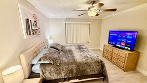 A bedroom with a bed, a ceiling fan, a television, and a dresser. - Grand Premier 3BD Condo Apartment Near Disney Parks 6 (Kissimmee)