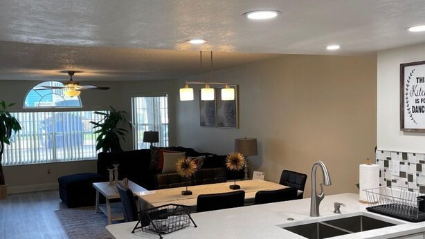 A modern kitchen with a central island, white cabinetry, and a built-in dishwasher. - Grand Family Superior 3BD Condo Near Disney 7 (Kissimmee)