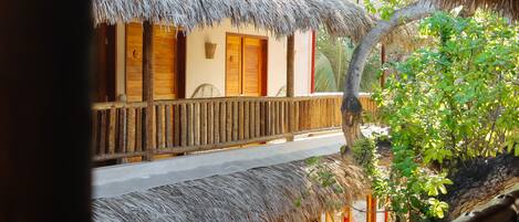 A thatched-roof building with wooden balconies and a stone wall.