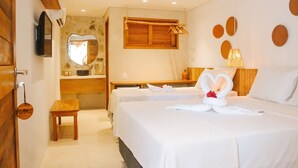 Ein Hotelzimmer mit zwei Betten, einem Holztisch, einem Spiegel und einem am Wand montierten Fernseher.