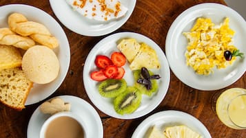 A breakfast table with various dishes including toast, fruit, scrambled eggs, and a cup of coffee.