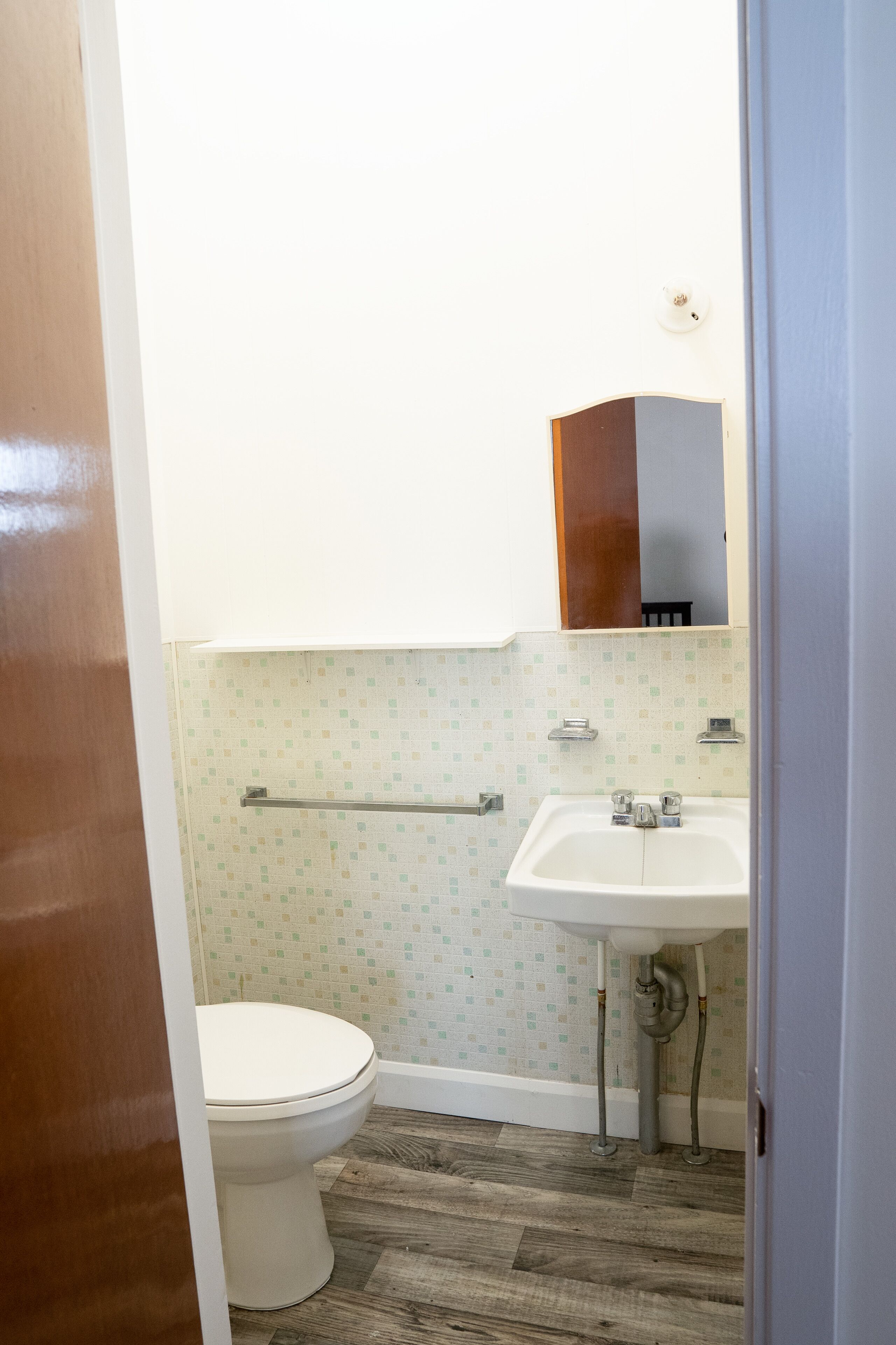 Ein Badezimmer mit Toilette, Waschbecken und Spiegel.