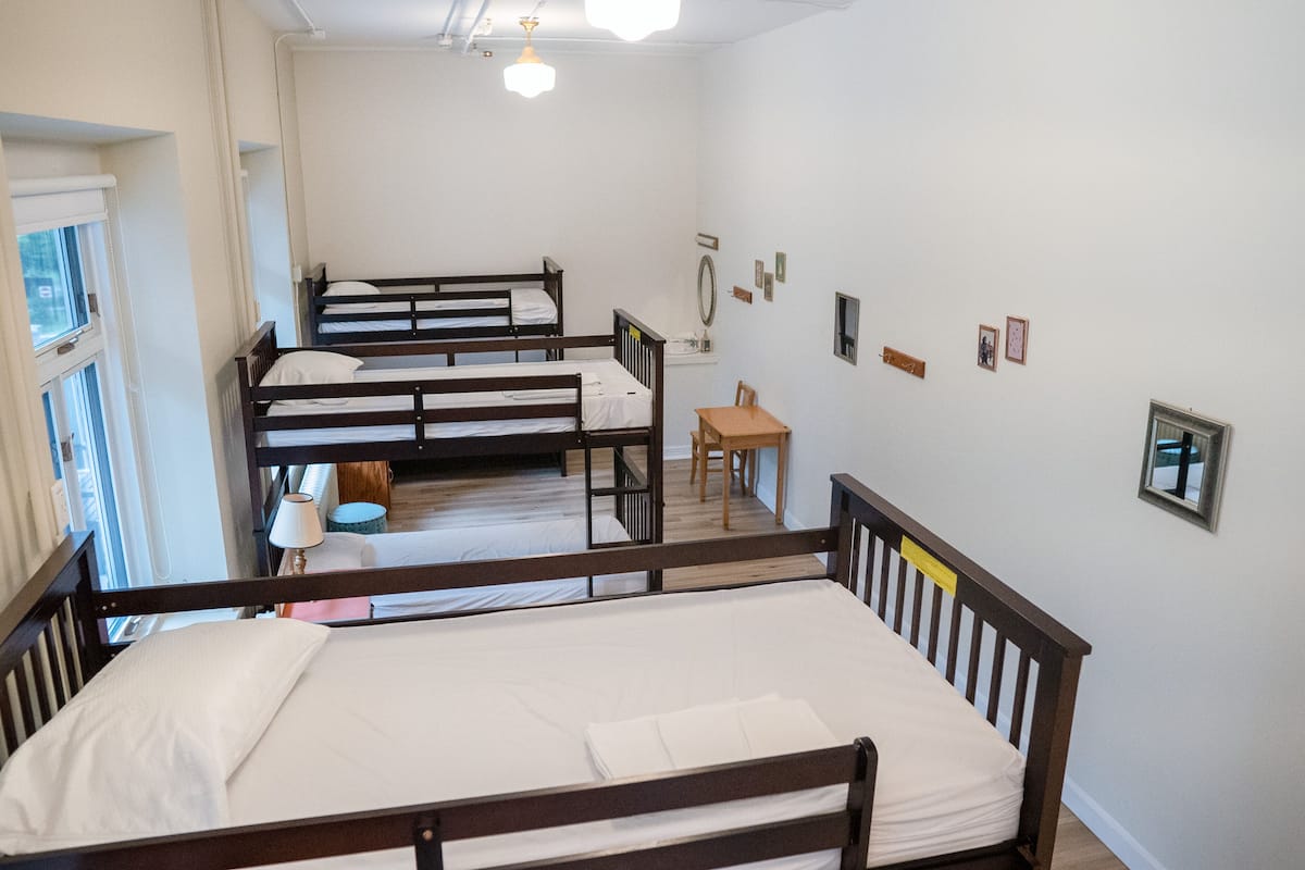 Un dormitorio con literas, una mesita y una silla.