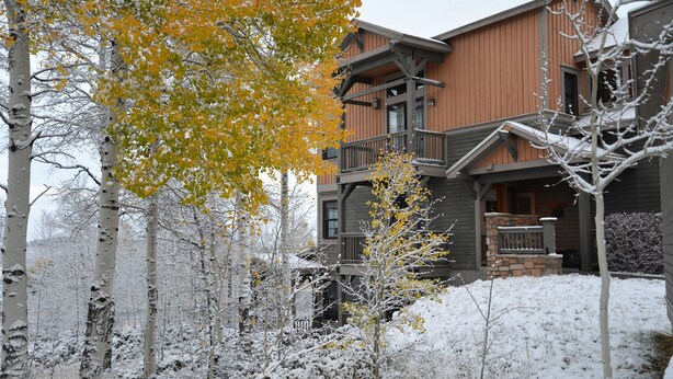 A two-story wooden lodge with a balcony and stone foundation.