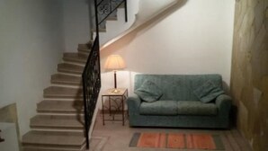 Un escalier menant à un palier où se trouvent une lampe et un canapé.