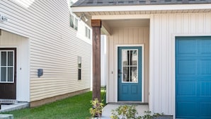 A two-story house with a blue front door and a garage door.