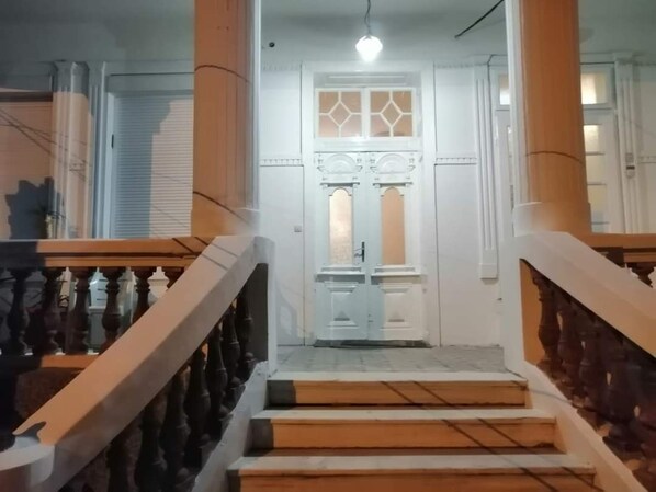 Una escalera que conduce a una puerta con un diseño geométrico de vidrio.