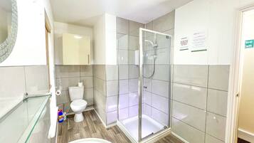 Un baño moderno con ducha de vidrio, inodoro y bañera.