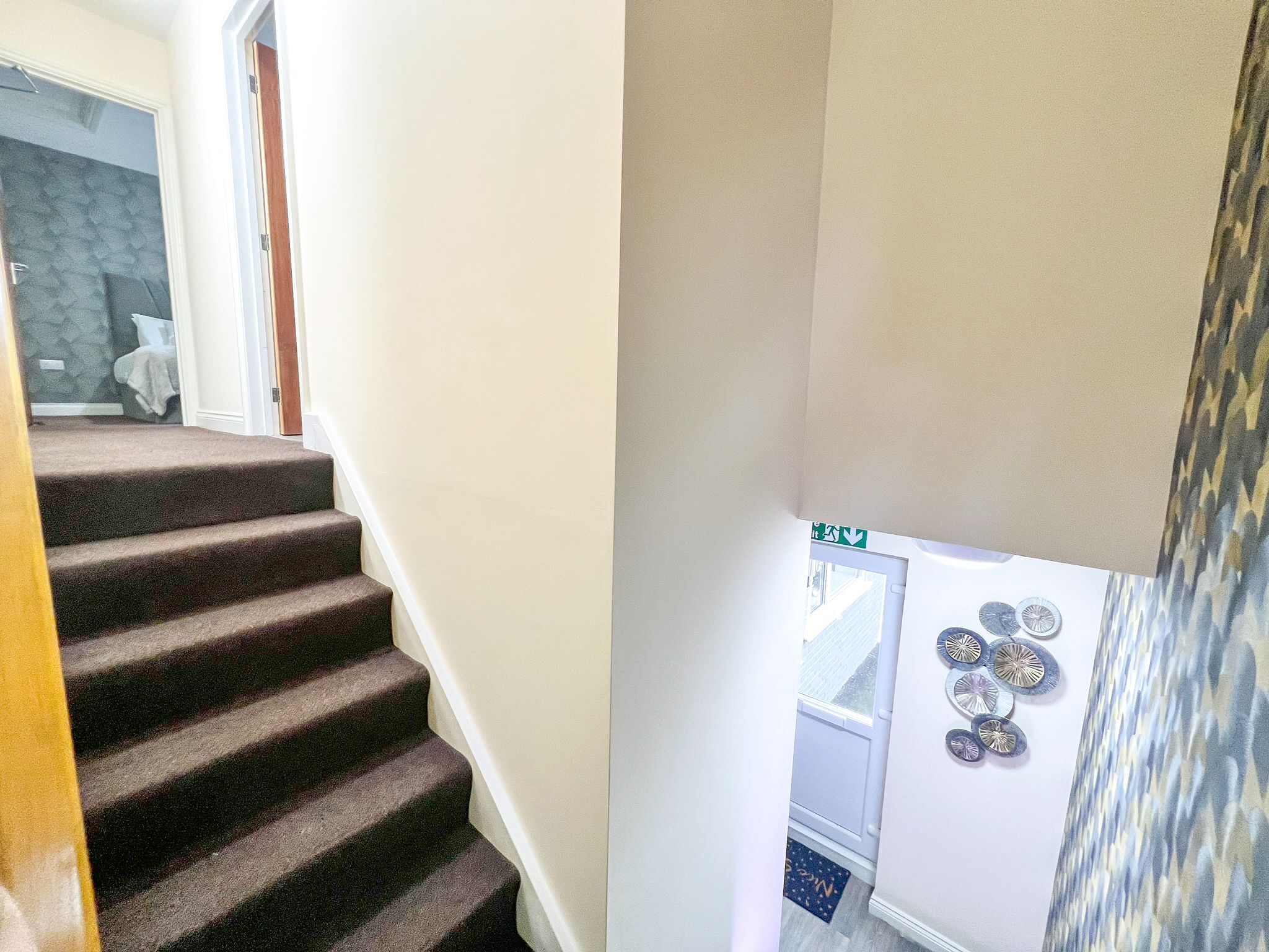 A staircase with carpeted steps leading to a landing.