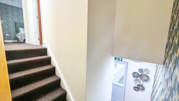 A staircase with carpeted steps leading to a landing.