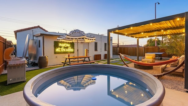 An outdoor pool area with a hot tub, a covered seating area, and a patio with a table and chairs. - NEW Modern 1940s Adobe - Downtown, Historic (Tucson)