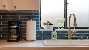 A kitchen with a coffee maker, a bottle of hand soap, and a sink with a faucet. - NEW Modern 1940s Adobe - Downtown, Historic (Tucson)