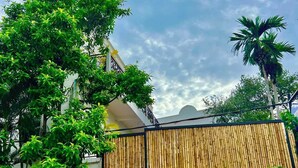 A building with a bamboo fence, a sign reading "pride Villa Cambodia", and lush greenery around. - Pride Villa Cambodia (Phnom Penh)