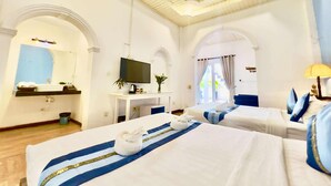 A hotel room with two beds, a TV, a desk with a plant, and a ceiling fan. - Pride Villa Cambodia (Phnom Penh)