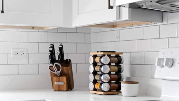 A kitchen with white cabinets, a knife block, a spice rack, and a coffee maker. - The Norwood Nook – Walkable Stay Near O’Hare & Metra! (Chicago)