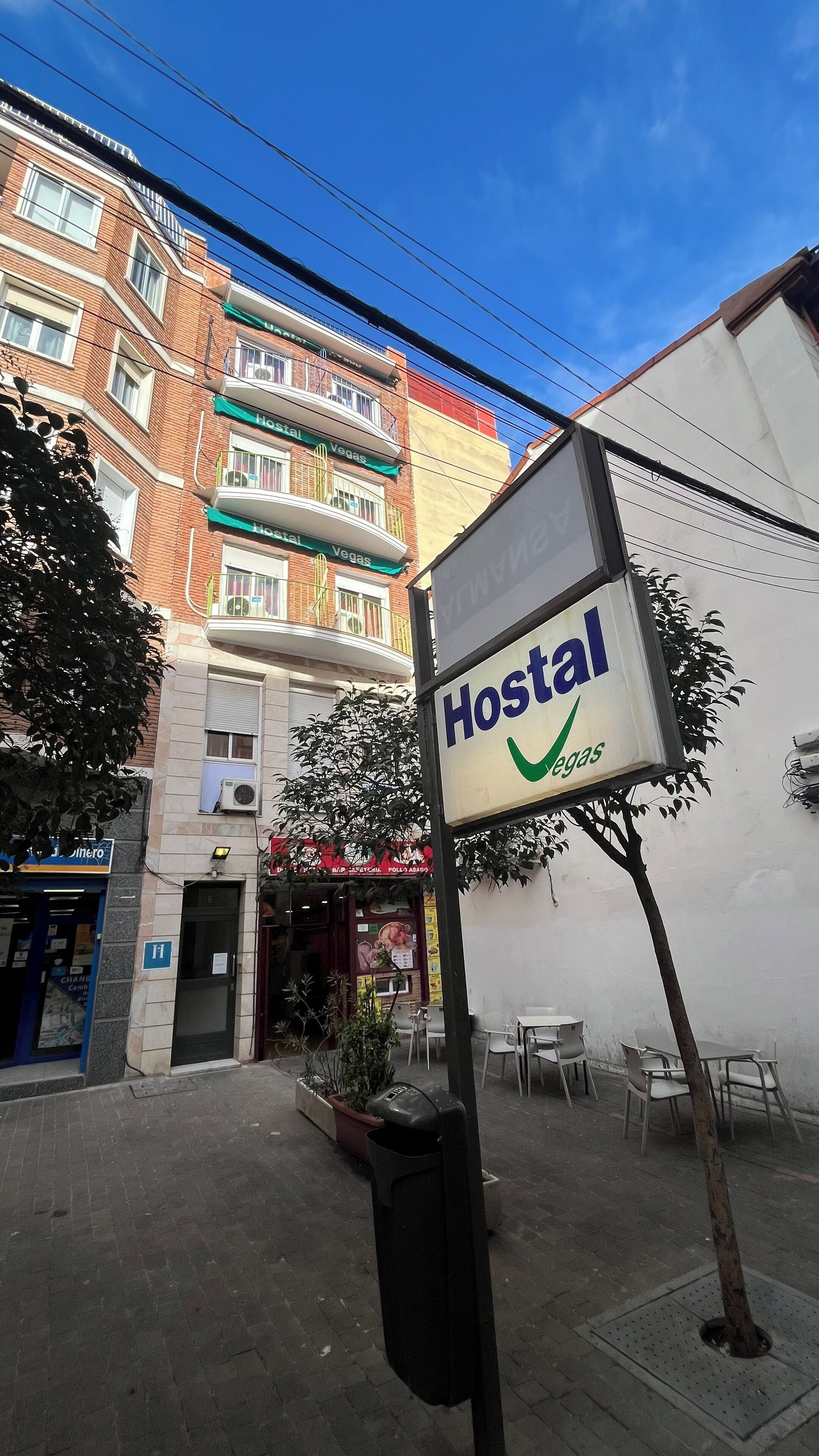 Letrero de un hostal con una marca de verificación verde que indica opciones veganas.
