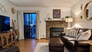 A living room with a fireplace, leather sofa, and a television. - Frisco Gateway to Skiing: Min to Breck + Keystone, Hot Tubs, Pickleball, Sauna (Frisco)